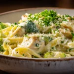 Creamy chicken and broccoli fettuccine alfredo in a rustic white bowl
