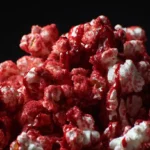 Bowl of bloody red velvet popcorn coated in white chocolate and cake mix