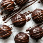 Healthy brownie protein bites arranged on parchment paper with chocolate drizzle