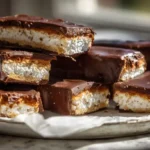 Homemade Kit Kat bars cut into neat pieces on a wooden board.