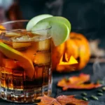 Poisoned apple cider cocktail in a glass garnished with green apple slices