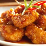 Crispy Orange Chicken garnished with sesame seeds and green onions