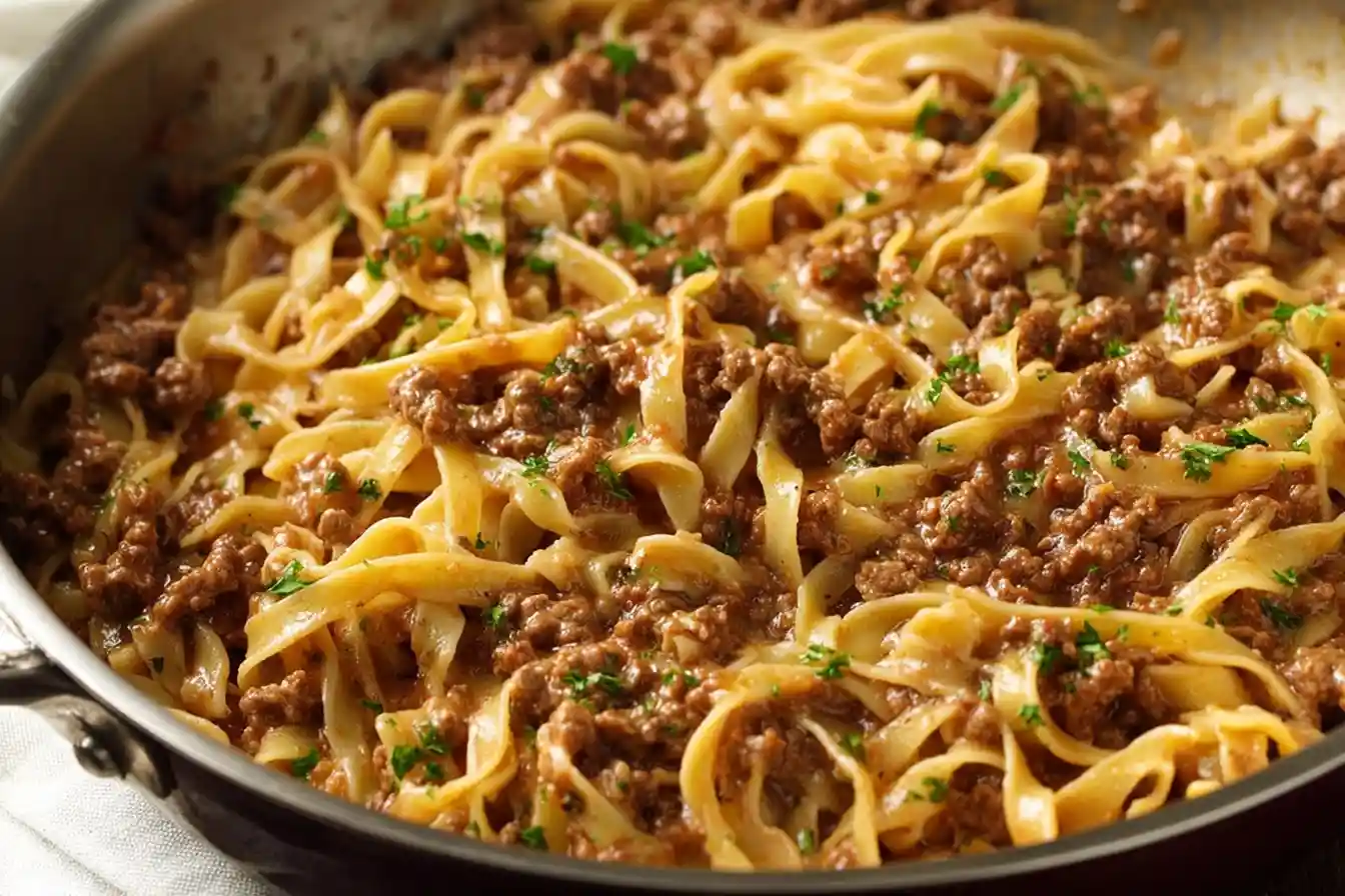 Bowl of beef and noodles garnished with fresh herbs