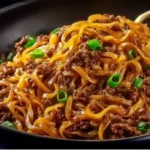 Delicious Mongolian Ground Beef Noodles served in a bowl with fresh vegetables