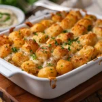 Golden tater tot casserole in baking dish with melted cheese bubbling