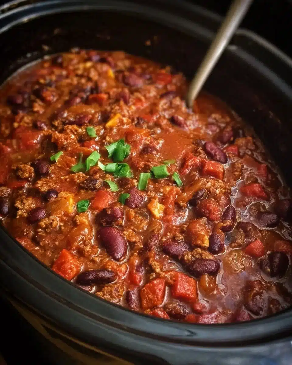 Bowl of easy slow cooker chili topped with cheese and fresh herbs