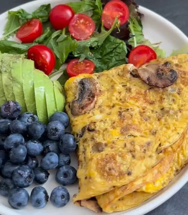 Delicious veggie omelette plate topped with fresh vegetables and herbs