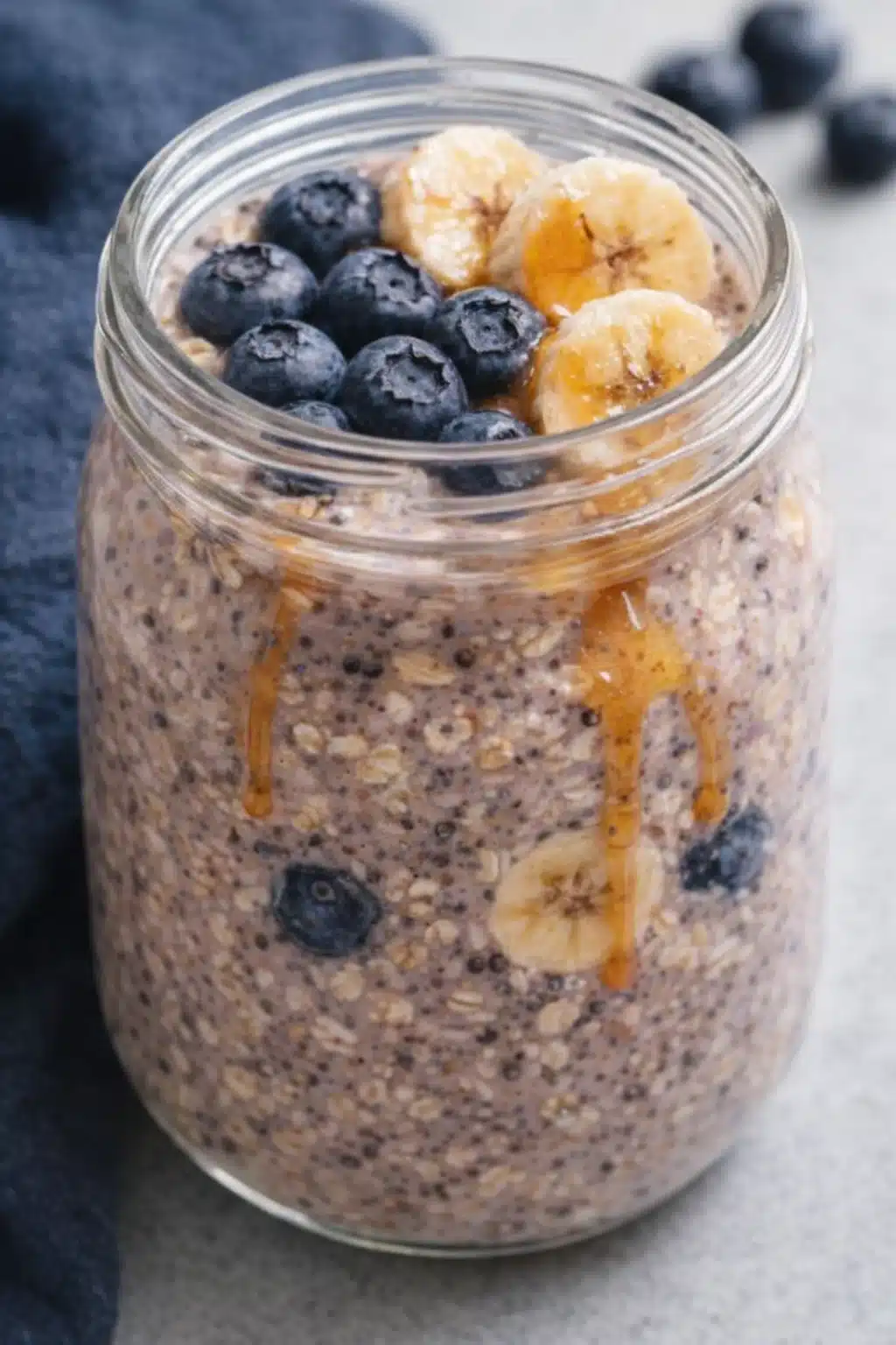 Bowl of blueberry banana overnight oats topped with fresh blueberries and banana slices.