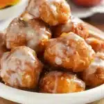 Homemade apple fritter bites with powdered sugar on a plate