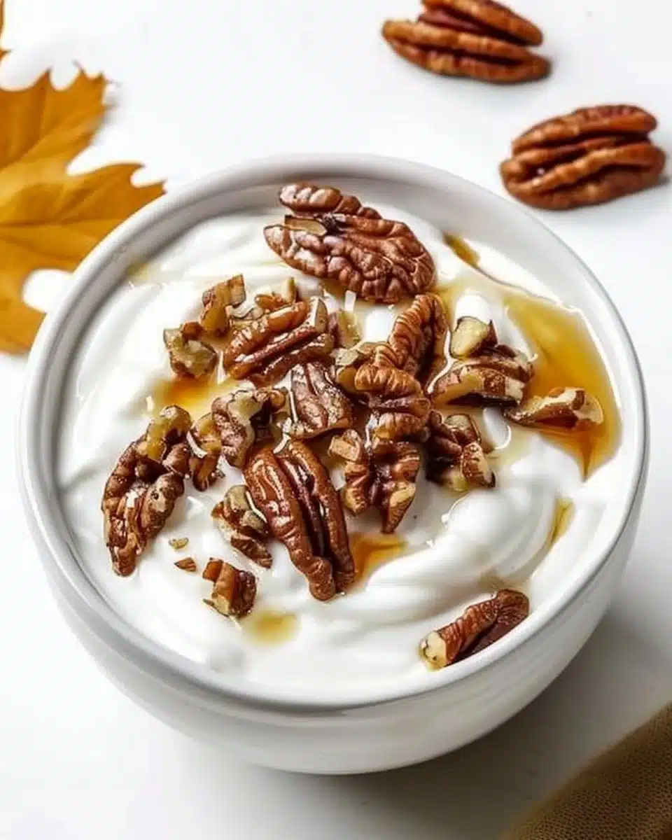 Delicious Maple Pecan Yogurt Bowl topped with pecans and maple syrup