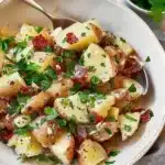 Traditional German Potato Salad served in a bowl with herbs and spices.