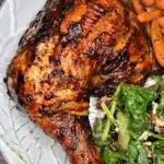 Delicious grilled BBQ chicken leg quarters on a platter