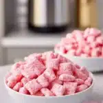 Bowl of Quick Strawberry Shortcake Puppy Chow with strawberries and whipped cream.