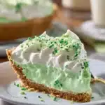 A slice of Shamrock Shake Pie topped with whipped cream and mint leaves.