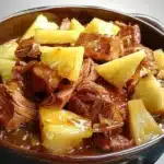 Slow Cooker Pineapple Pork served with rice and garnished with pineapple slices.