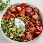 Colorful Strawberry Salad topped with fresh greens and nuts
