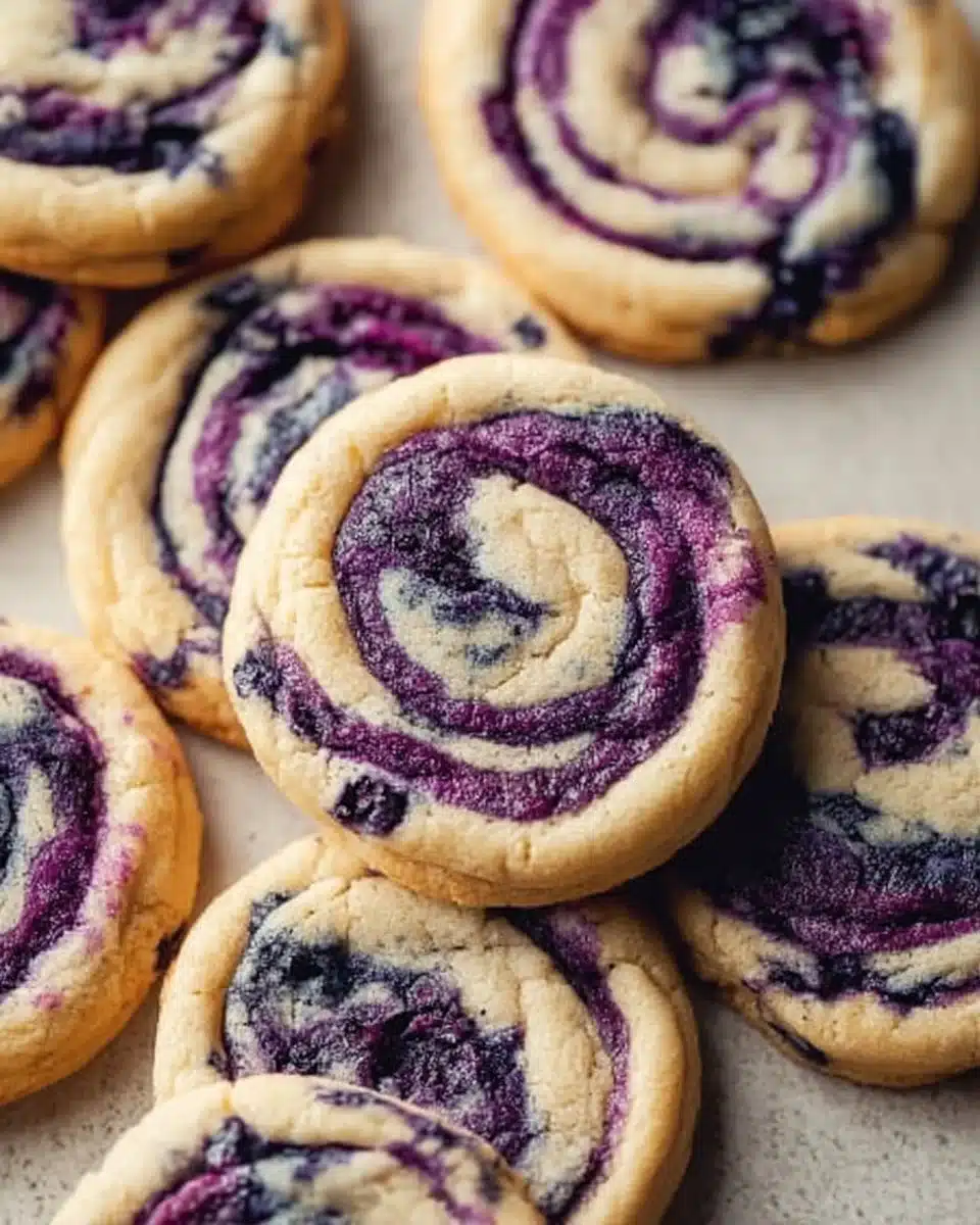 Blueberry cheesecake cookies topped with fresh blueberries and creamy cheesecake frosting