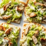 Delicious Chicken Caesar Flatbread topped with fresh lettuce and creamy dressing.