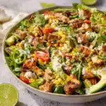 A vibrant chicken chopped salad with fresh vegetables and dressing