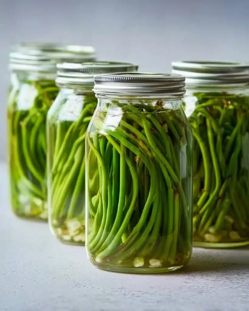 Jars of easy pickled garlic scapes ready for preservation