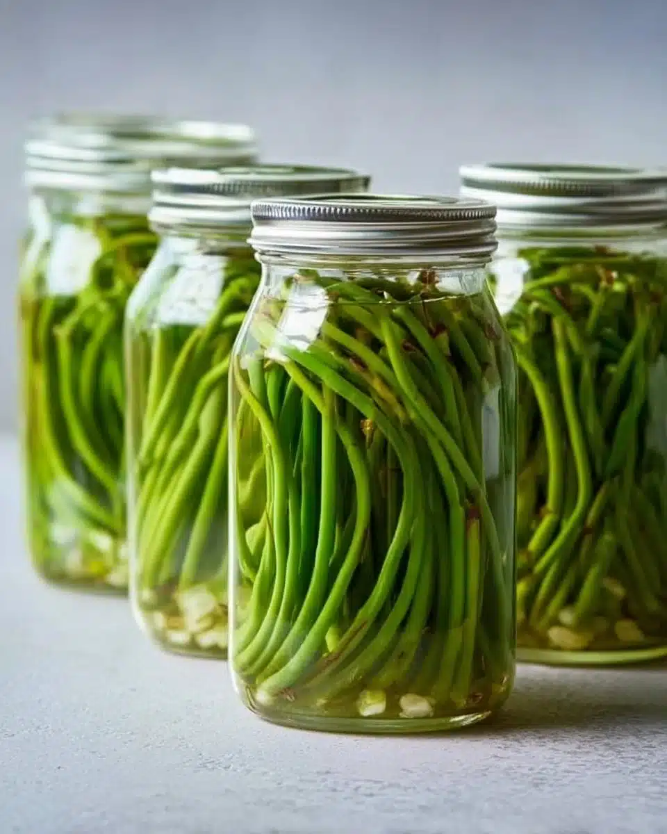 Jars of easy pickled garlic scapes ready for preservation