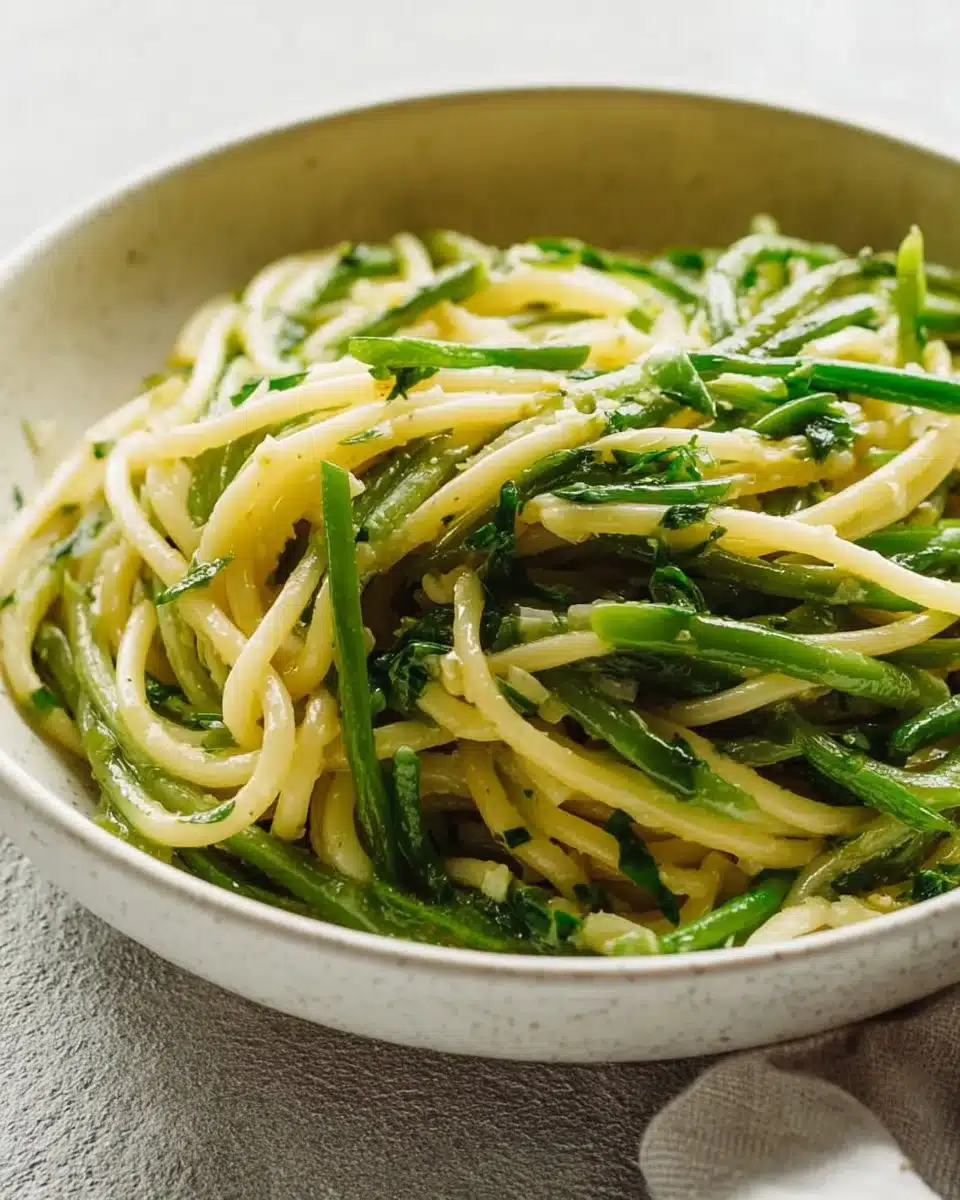 Garlic scape pasta garnished with fresh herbs and cheese