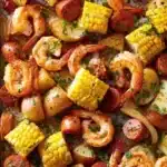 Delicious sheet pan shrimp boil with shrimp, potatoes, and corn on a baking tray.