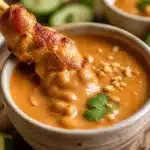 Delicious Chicken Satay skewers with creamy peanut sauce on a plate.