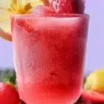 A refreshing glass of Frozen Strawberry Lemonade topped with fresh strawberries
