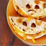 Halloween-themed Jack o' Lantern quesadillas filled with cheese and veggies.