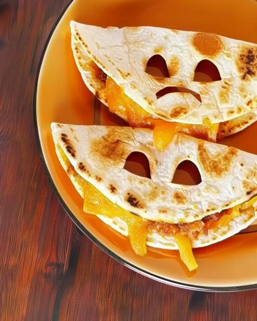 Halloween-themed Jack o' Lantern quesadillas filled with cheese and veggies.