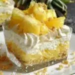 No bake pineapple cream dessert served in a glass with tropical decorations.